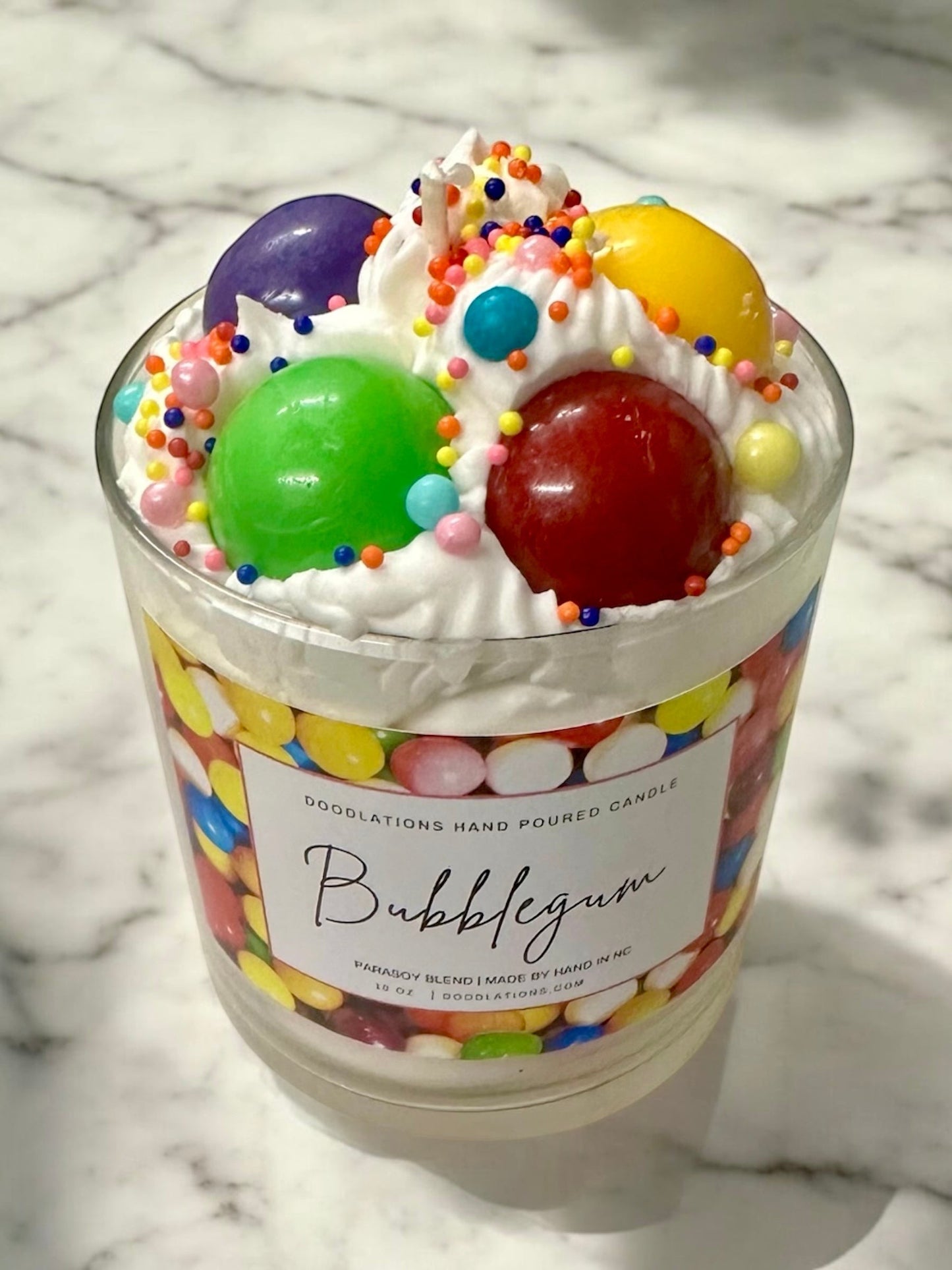 Doodlations Coffee Bar & Boutique Bubblegum candle with whipped wax topping, candy sprinkles, and a colorful gumball wrapper design.