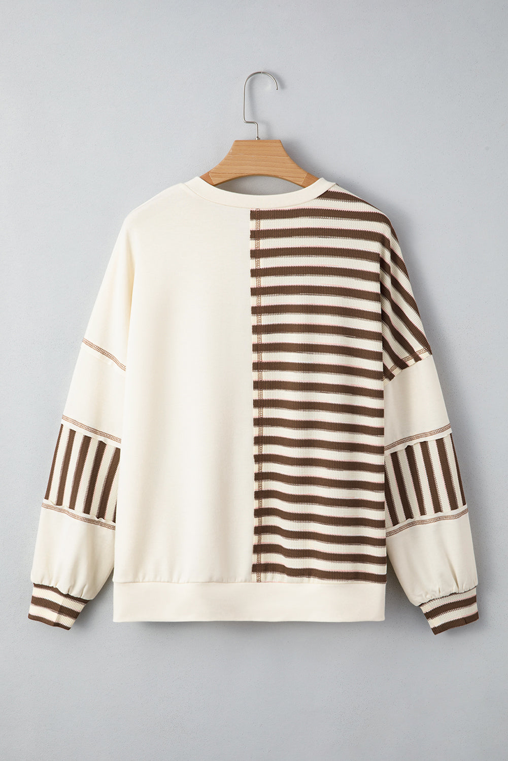 White sweater with brown horizontal stripes on a gray background