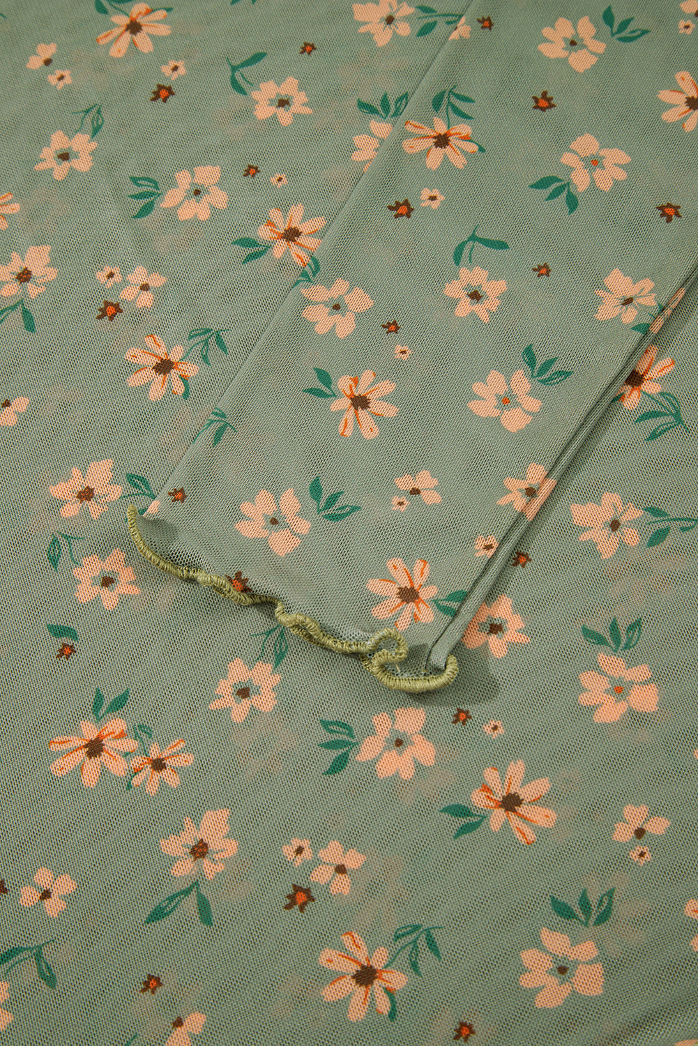 Floral patterned fabric with a needle on a green background