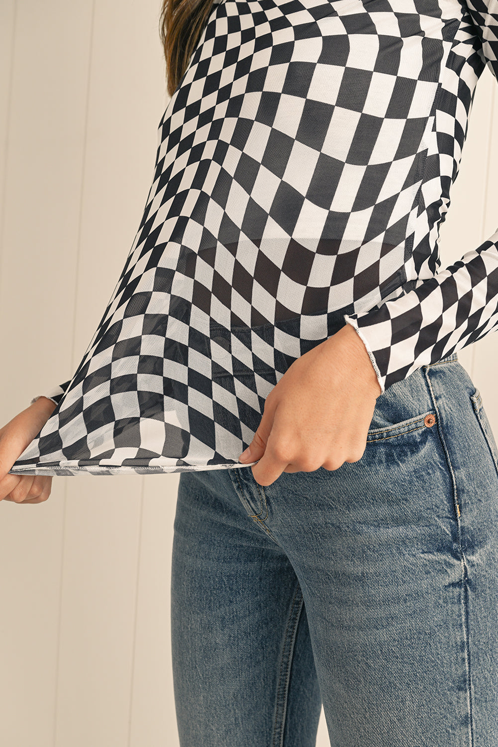 Person wearing a black and white checkered shirt with a blurred background