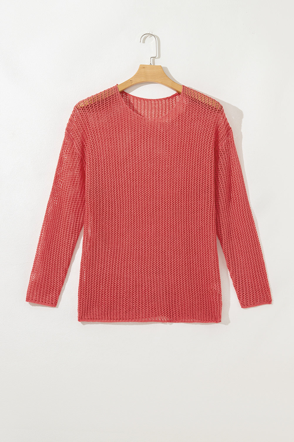 Red knitted sweater on a hanger against a white background