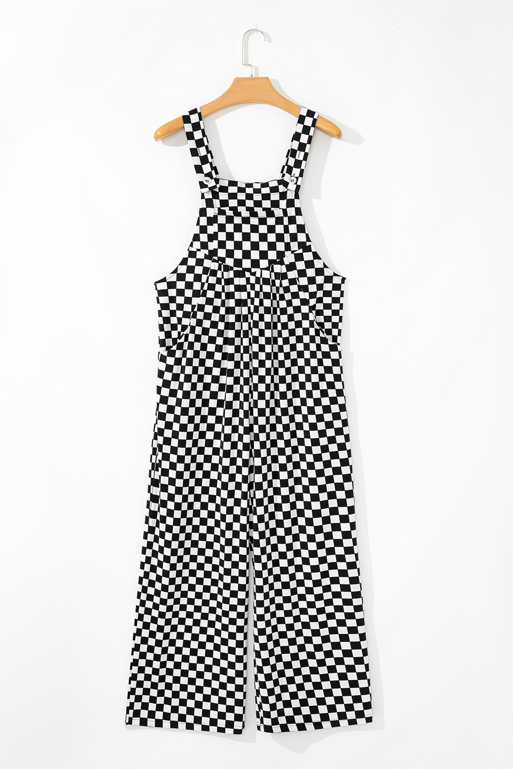 Black and white checkered jumpsuit on a hanger against a white background