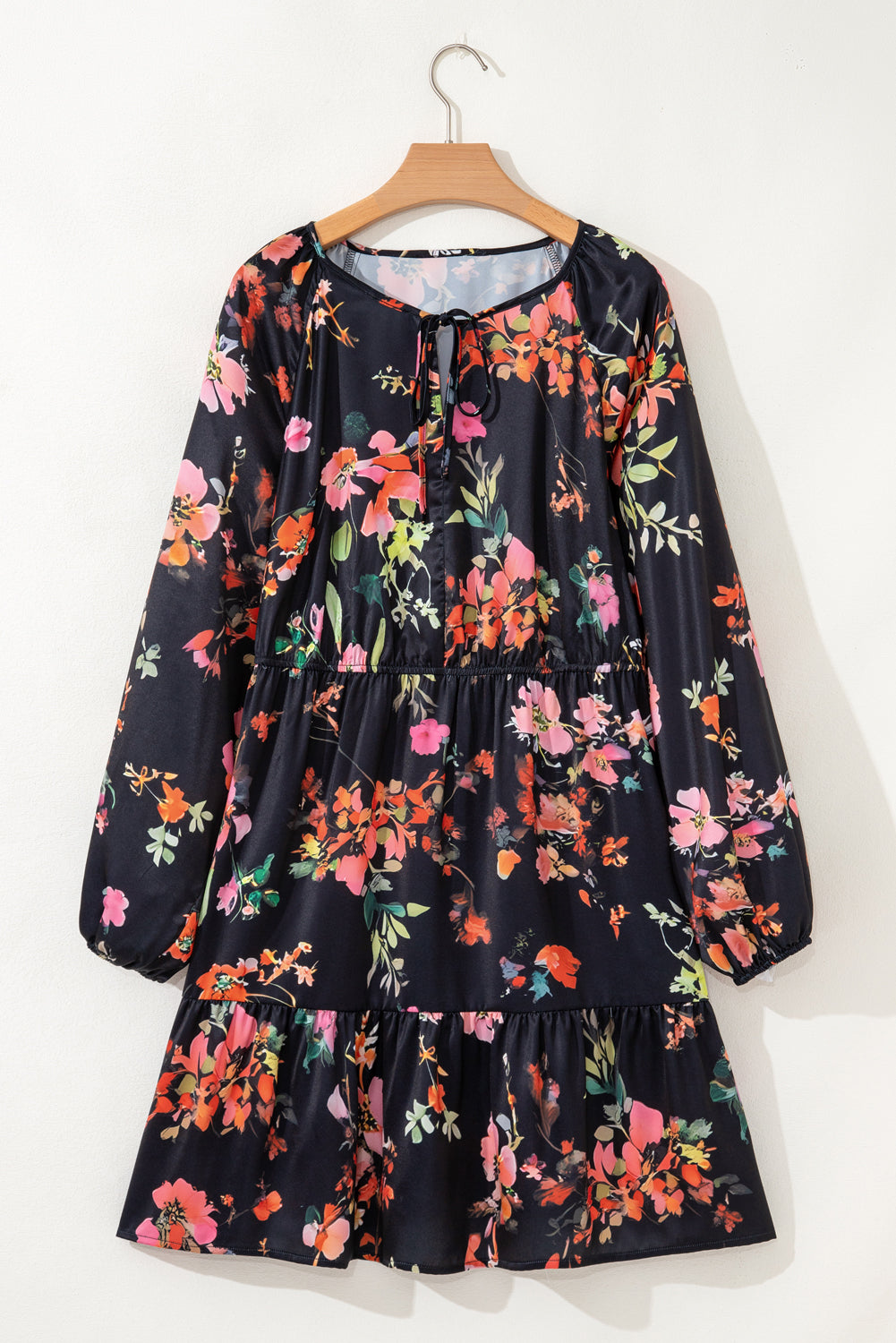 Floral dress on a hanger against a white background