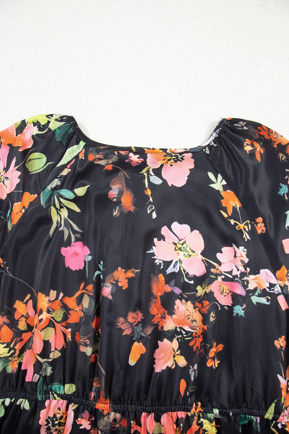 Black dress with colorful floral pattern on a white background