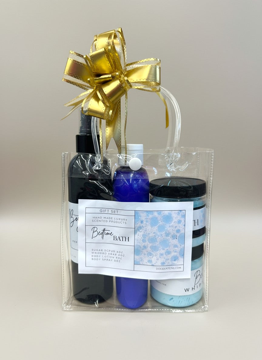 Doodlations Coffee Bar & Boutique Bedtime Bath gift set in a clear tote bag with a gold bow. Includes sugar scrub, whipped soap, body lotion, and body spray.