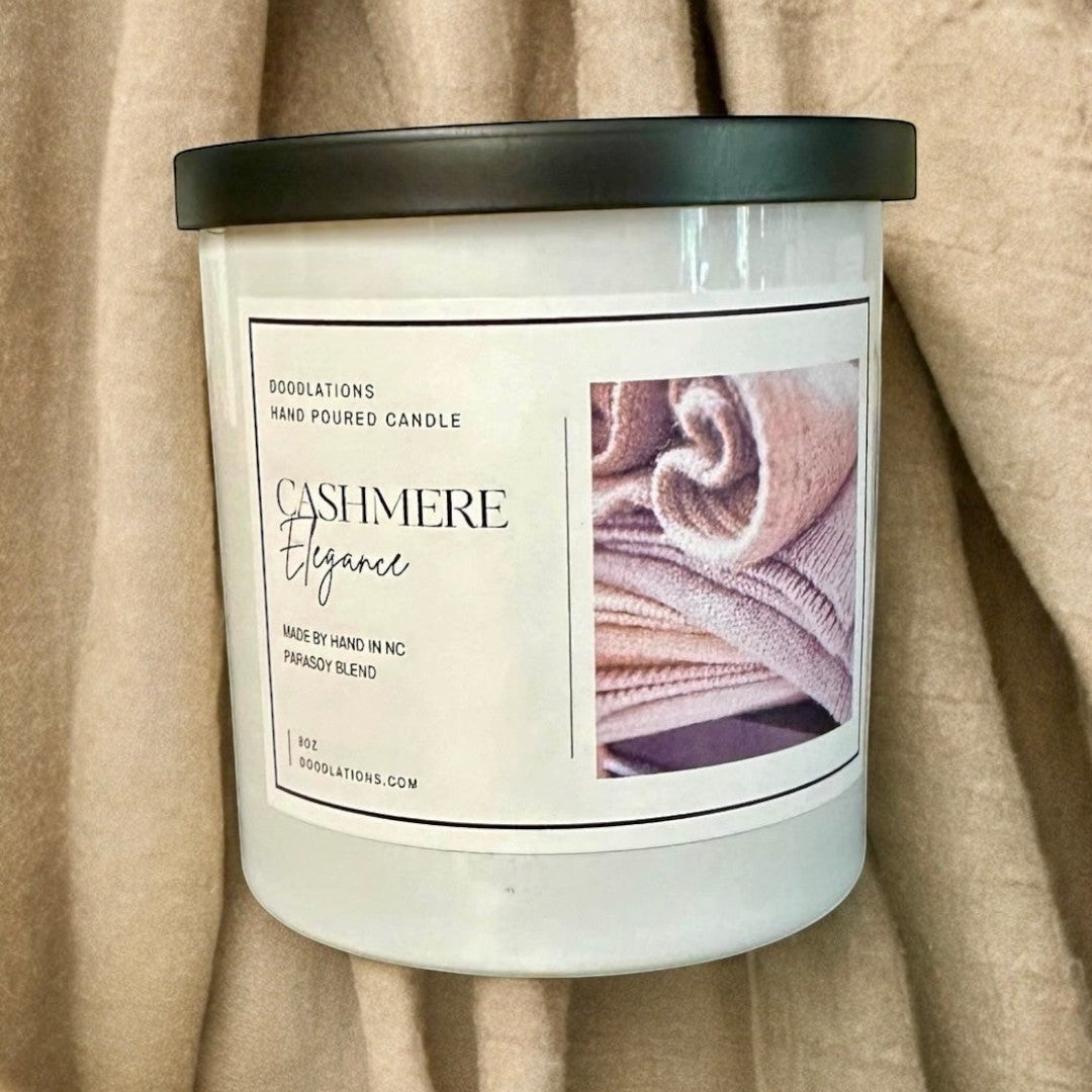 Doodlations Cashmere Elegance hand-poured candle with a parasoy blend, featuring notes of amber, sugar, vanilla, plum, and cherry.