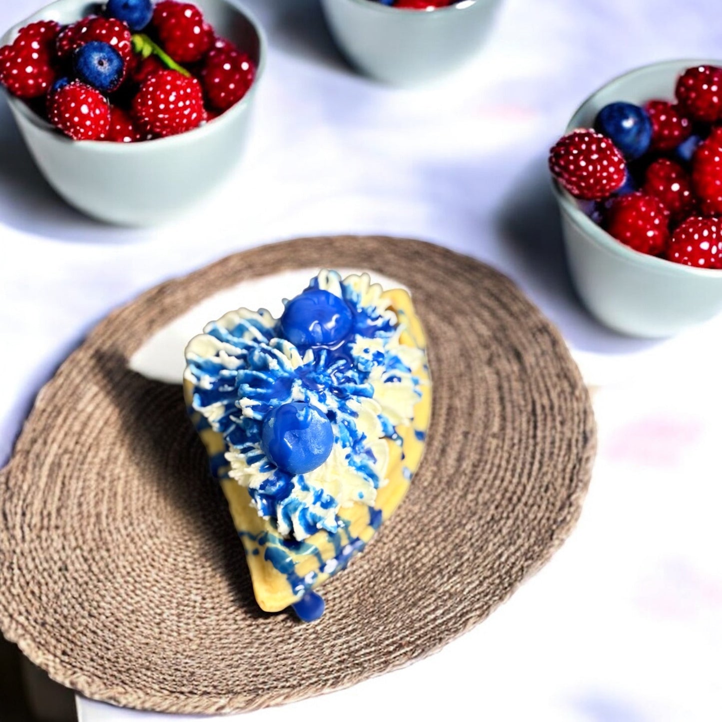 Doodlations Coffee Bar & Boutique Blueberry Waffle wax melt shaped like a slice of pie, topped with blue icing and blueberries.