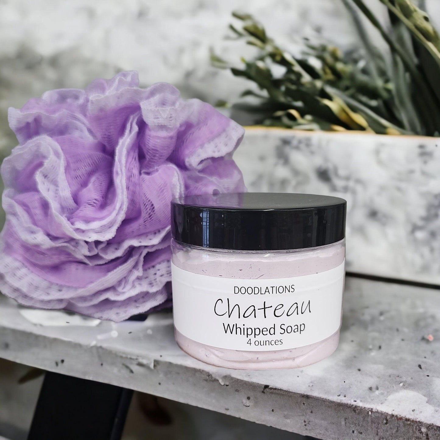 Doodlations Coffee Bar & Boutique Chateau whipped soap in a 4oz jar with a grape scent and purple bath loofah.