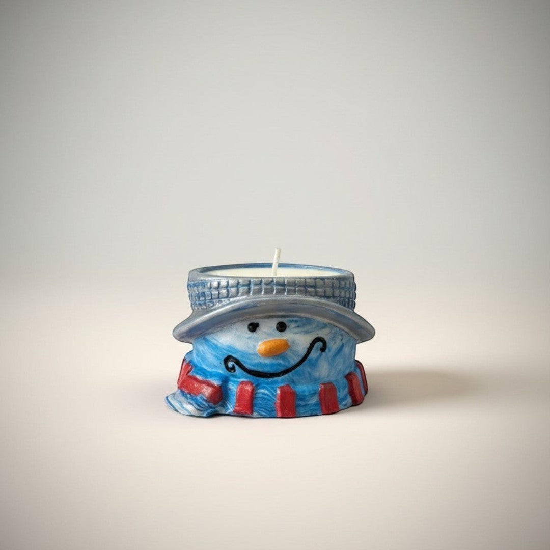 Doodlations Coffee Bar & Boutique snowman tea light holder with blue scarf and black hat, orange nose, and smiling face.