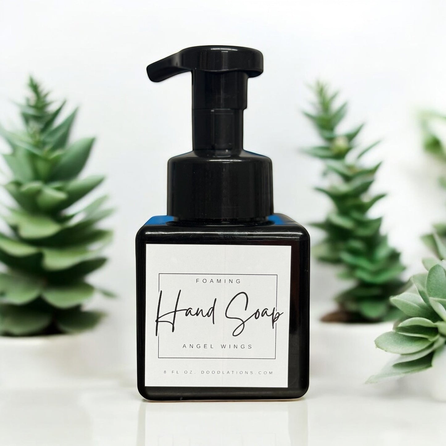 Doodlations Coffee Bar & Boutique Angel Wings foaming hand soap in a black bottle with a white label.