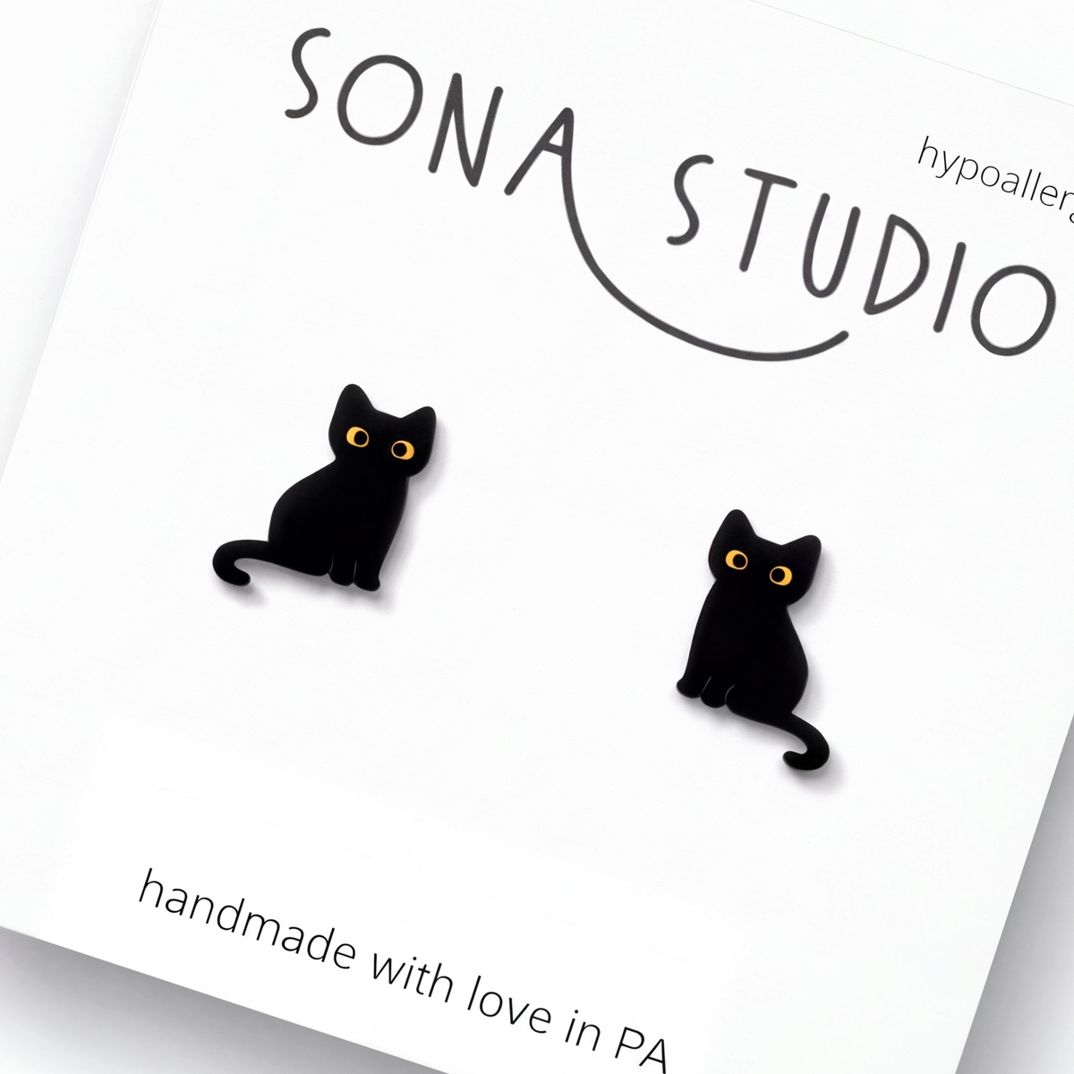 Doodlations Coffee Bar & Boutique handcrafted black cat earrings with bright yellow eyes and stainless steel posts.