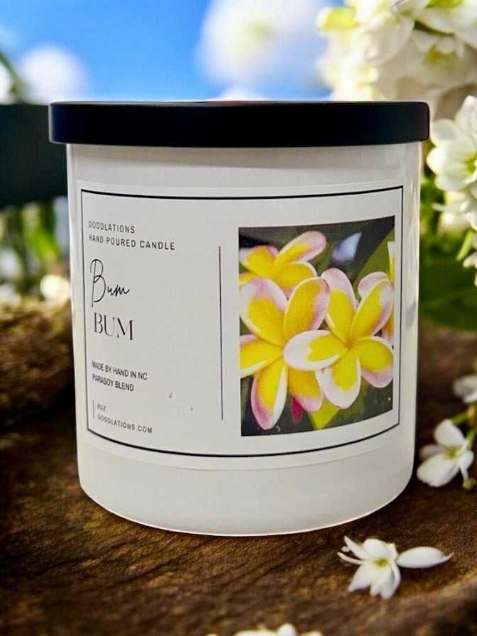 Doodlations Coffee Bar & Boutique Bum Bum luxury candle in white glass jar with black lid, tropical floral label.