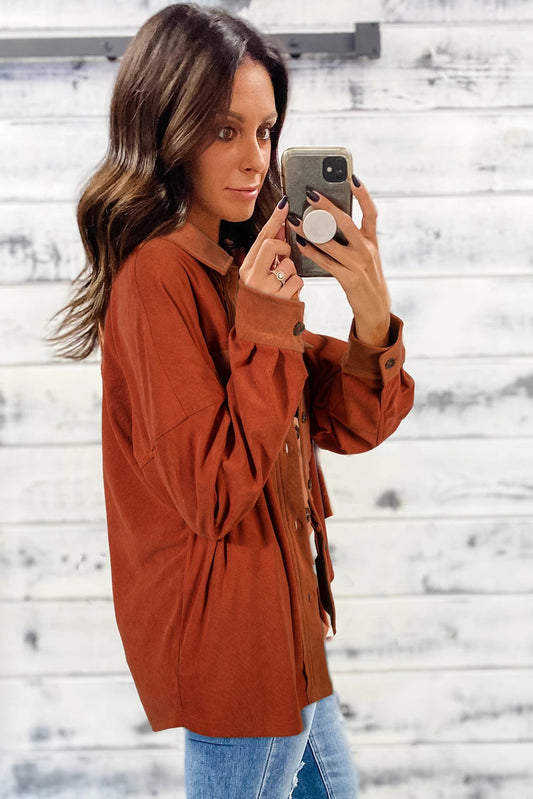 Doodlations Coffee Bar & Boutique burnt orange velvet shacket with drop shoulders and button-up front on a woman.