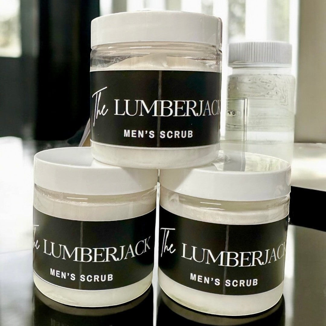 Doodlations Coffee Bar & Boutique The Lumberjack Men's Scrub in clear jars with black labels. Creamy white scrub inside.