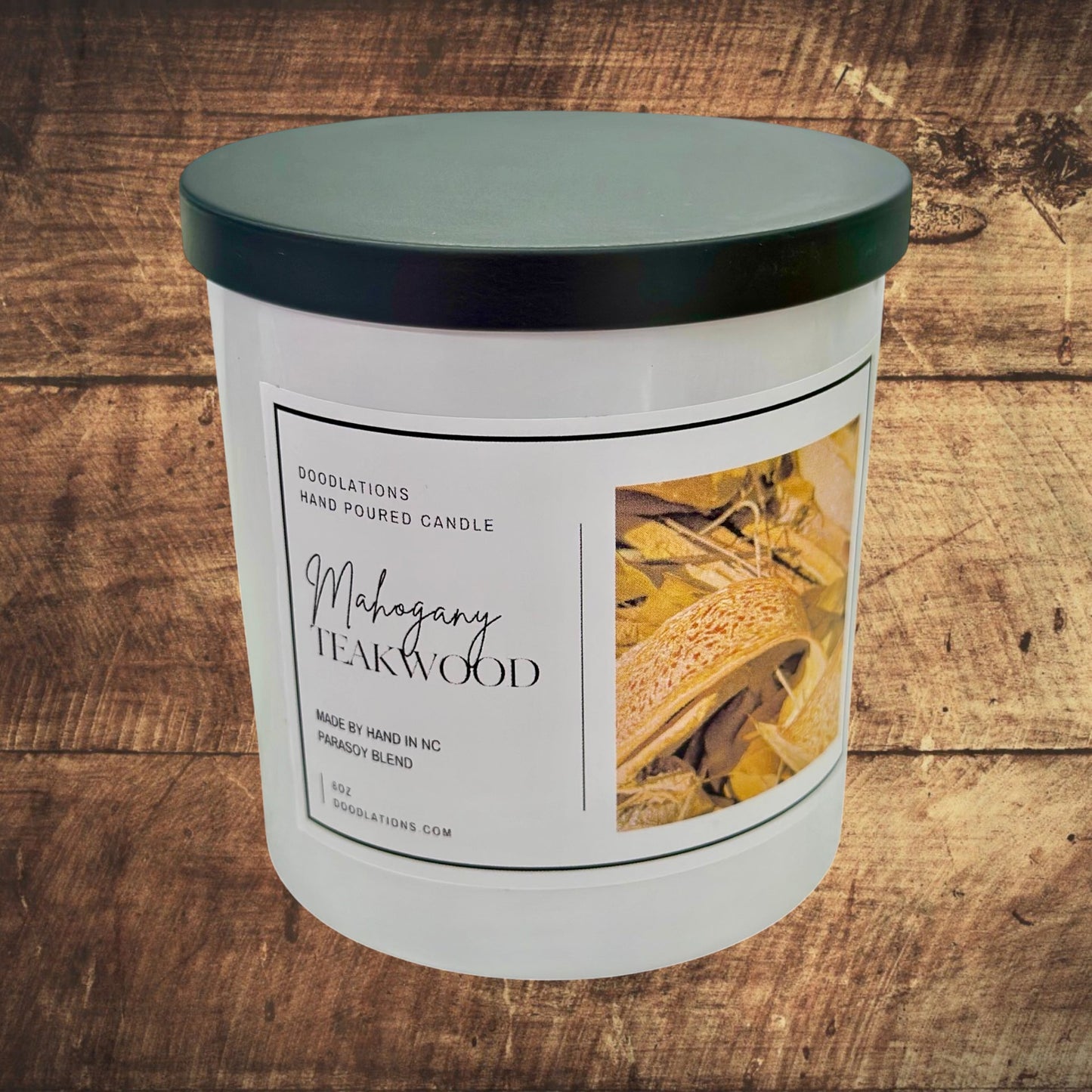 Doodlations Coffee Bar & Boutique Mahogany Teakwood hand-poured 8oz soy wax candle with a black lid.