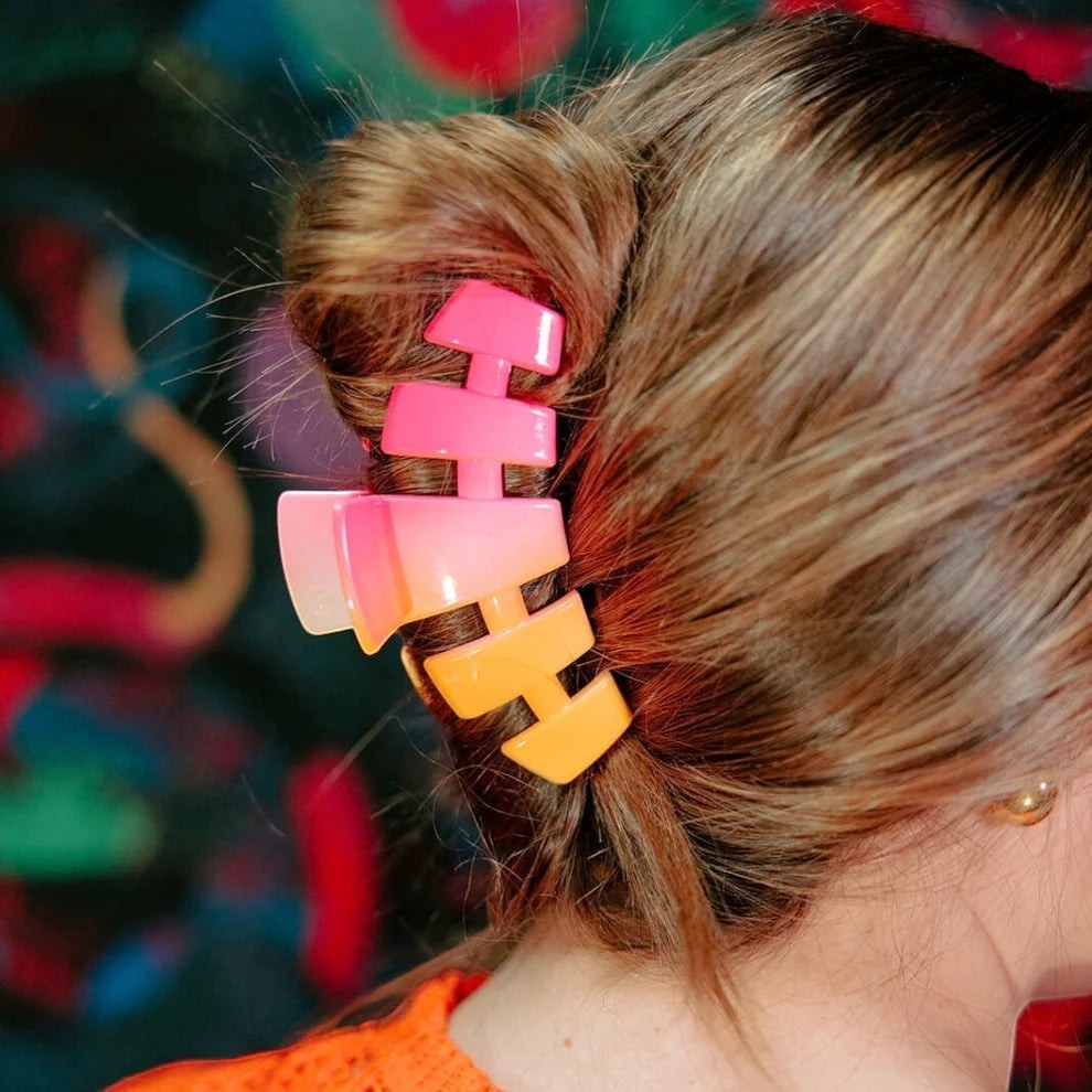 Doodlations Coffee Bar & Boutique pink and orange ombre segmented claw hair clip holding up brown hair.