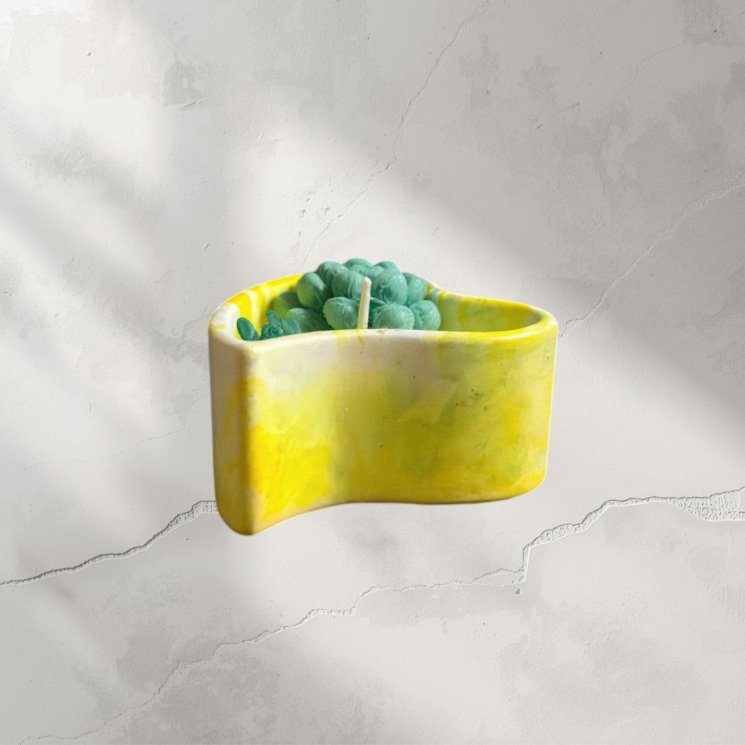 Doodlations yellow and white marbled heart-shaped concrete candle with green succulent wax melt.