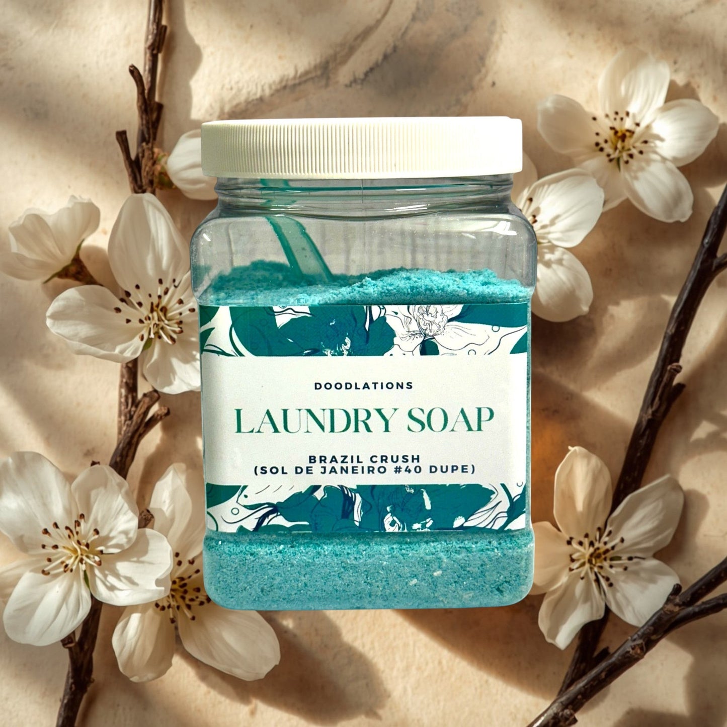 Doodlations Luxury Laundry Powder in Brazilian Crush scent, a turquoise powder in a clear jar with floral and leaf design.