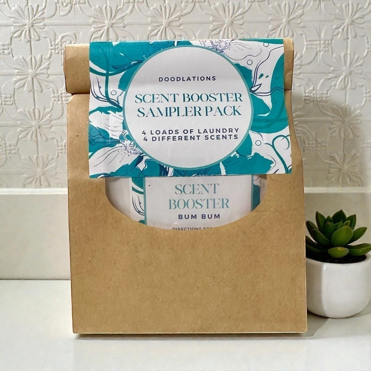 Doodlations Scent Booster Sampler Pack with 4 different laundry scents in a brown paper bag.