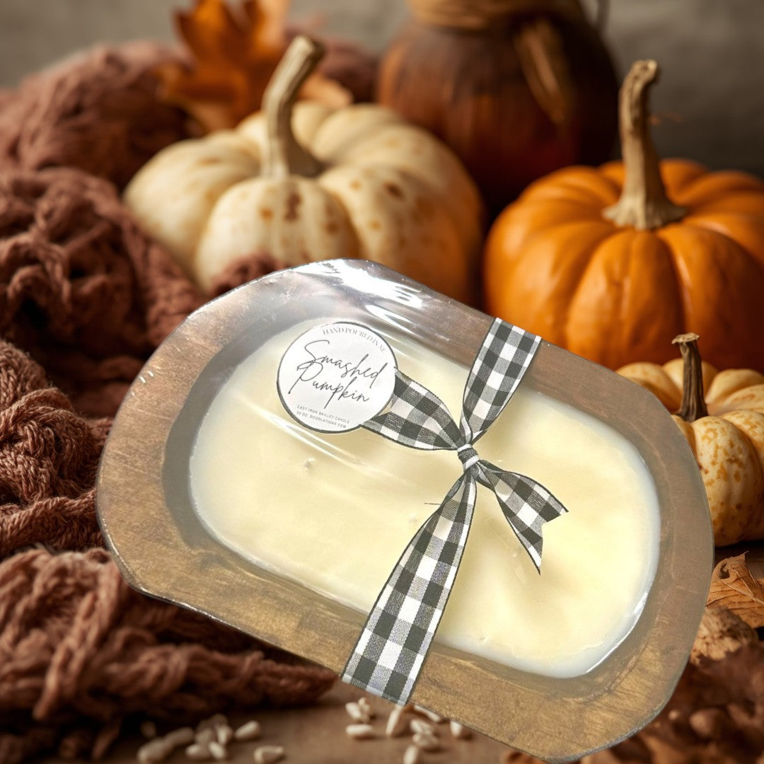 Doodlations Smashed Pumpkin wooden dough bowl candle with a black and white gingham ribbon.