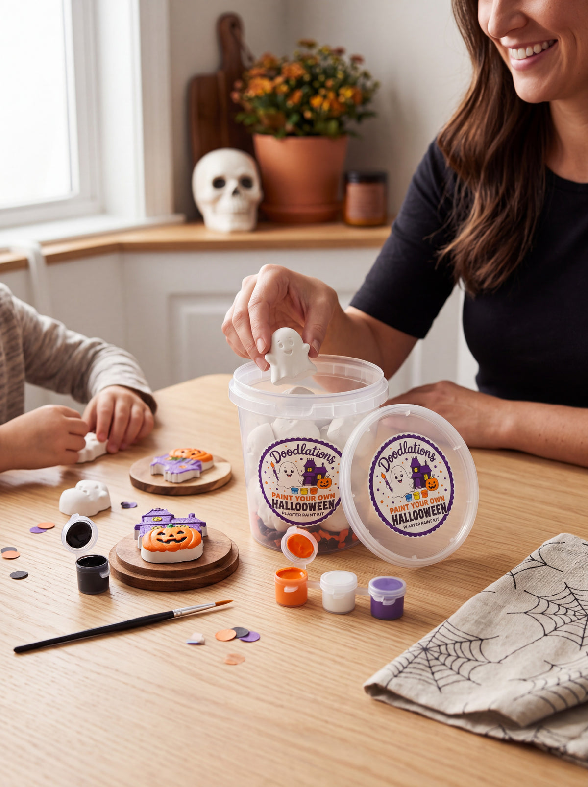 Doodlations Coffee Bar & Boutique Halloween plaster painting kit with ghost and pumpkin figurines on a wooden table