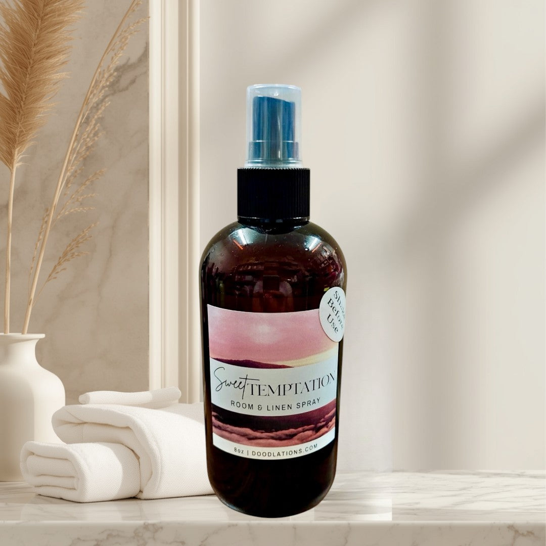 Sweet Temptation room and linen spray in a dark amber bottle with a pink and white label.
