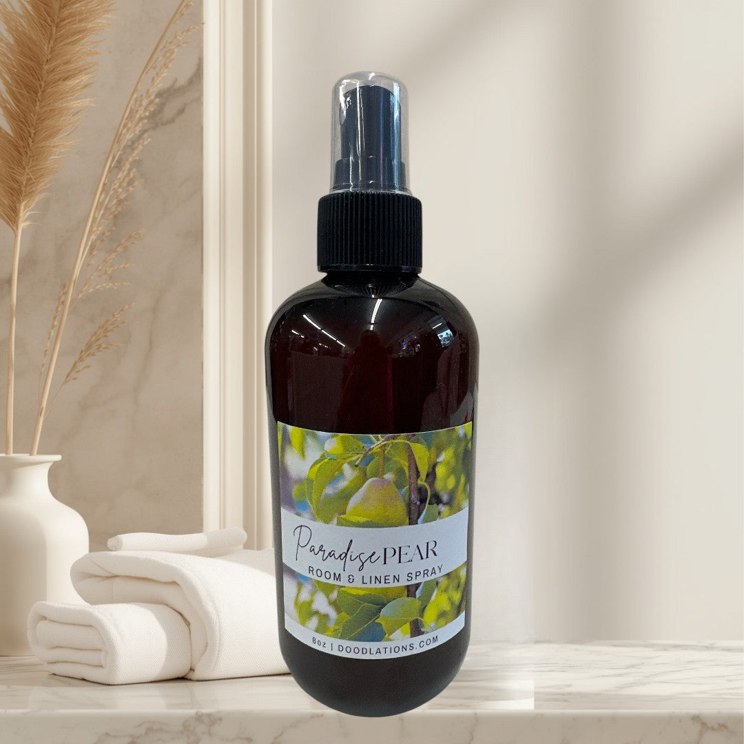 Paradise Pear Room & Linen Spray in amber bottle with spray top. Features pear illustration.