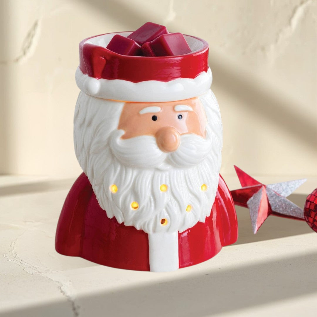 St. Nick fragrance warmer shaped like Santa Claus, with red suit and white beard, glowing warmly.