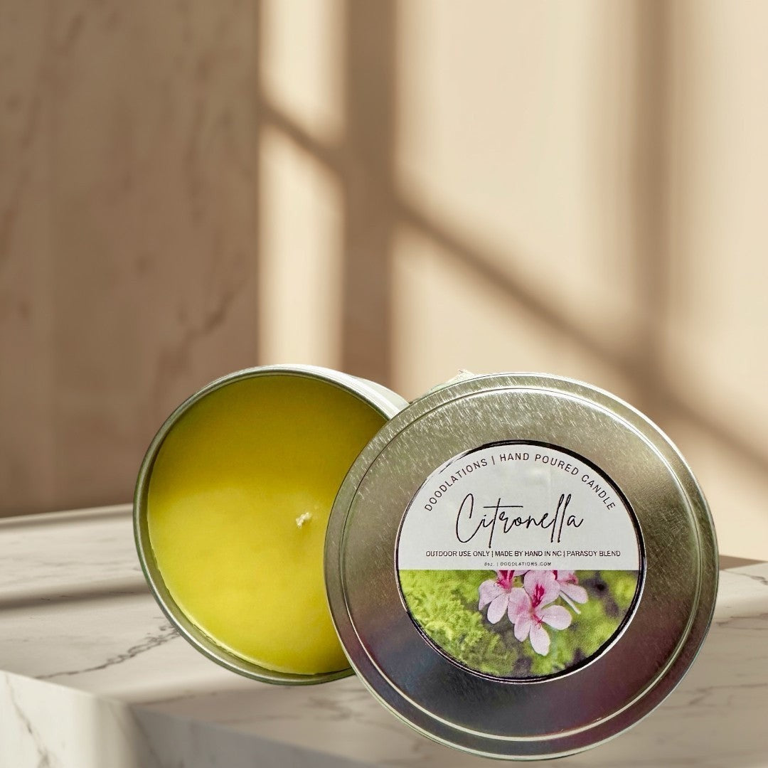 Citronella outdoor candle in a silver tin with a label featuring pink flowers and greenery.