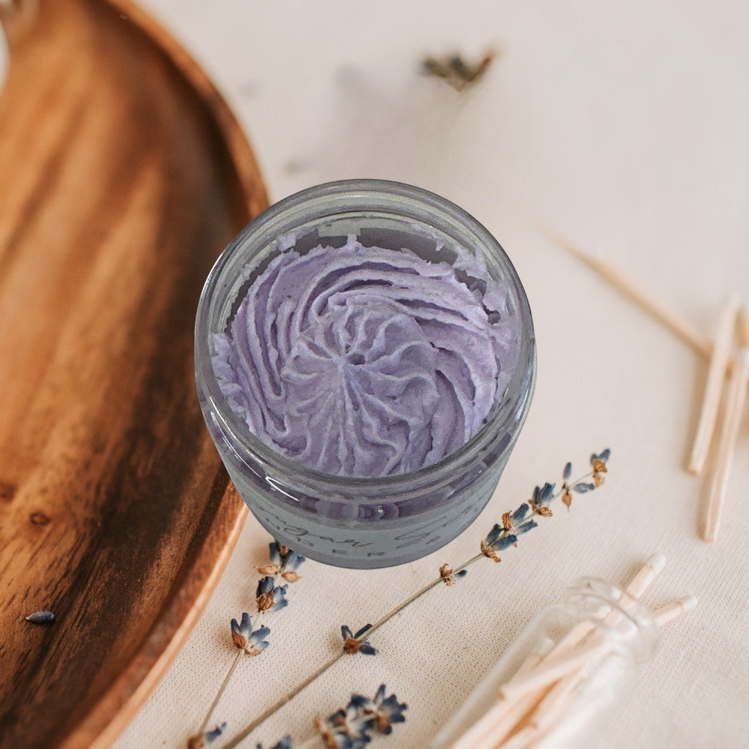 Lavender & Lemon Sugar Scrub in a clear jar with a black lid, featuring purple and white scrub layers.