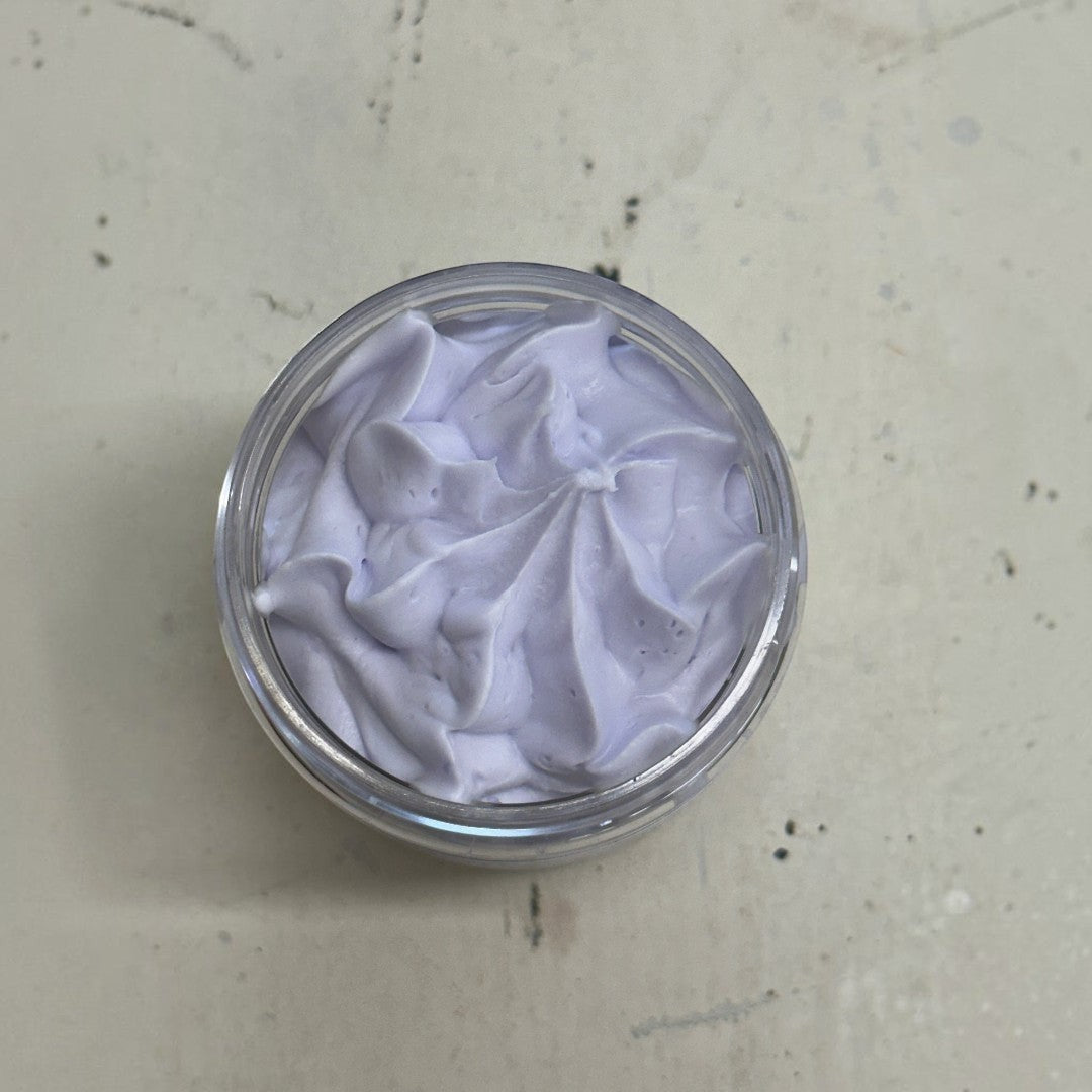 lavender and lemon whipped soap in a jar with a wooden scoop on a sunny bathroom sill