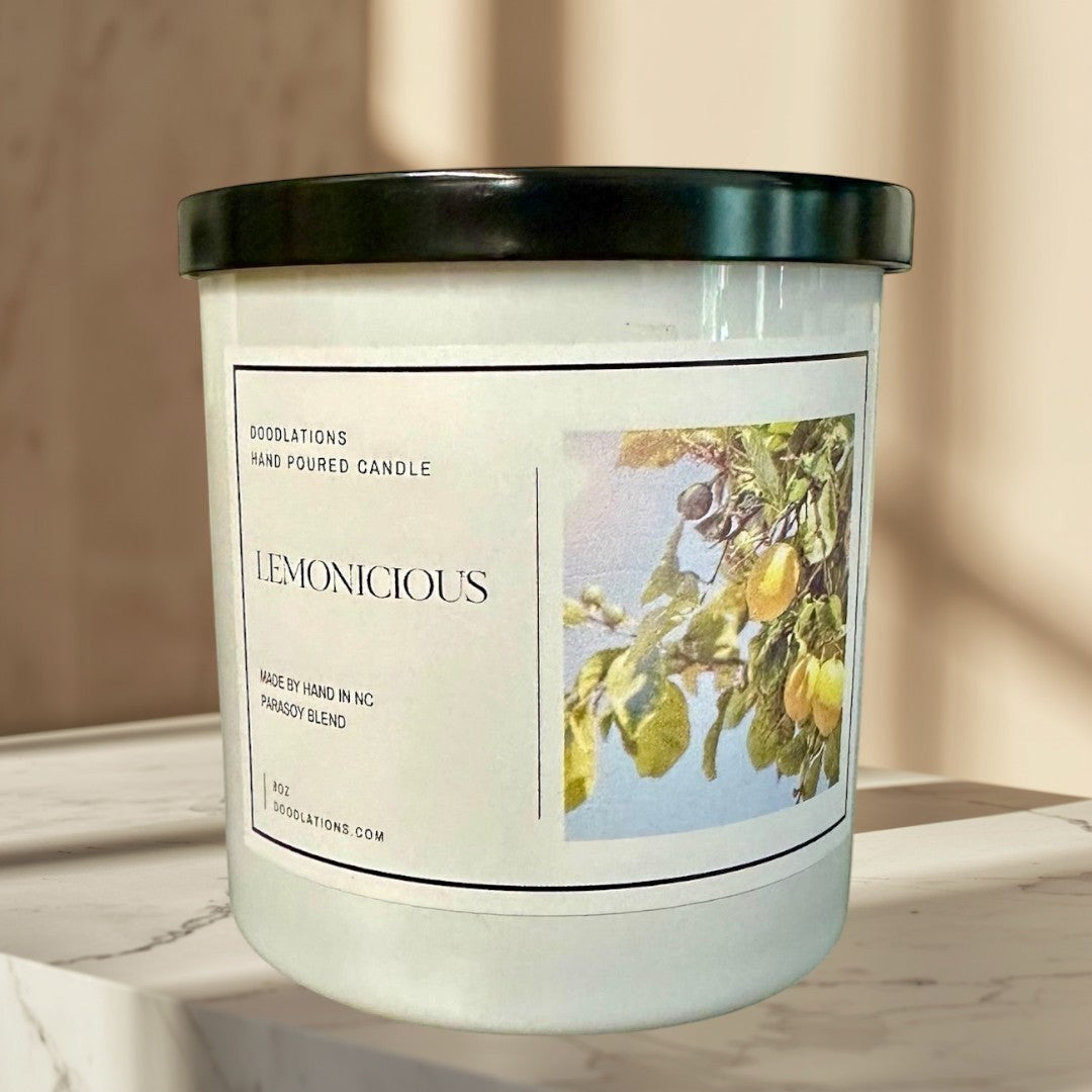 Lemonicious hand-poured soy blend candle with a bright citrus scent, featuring lemons on a branch.