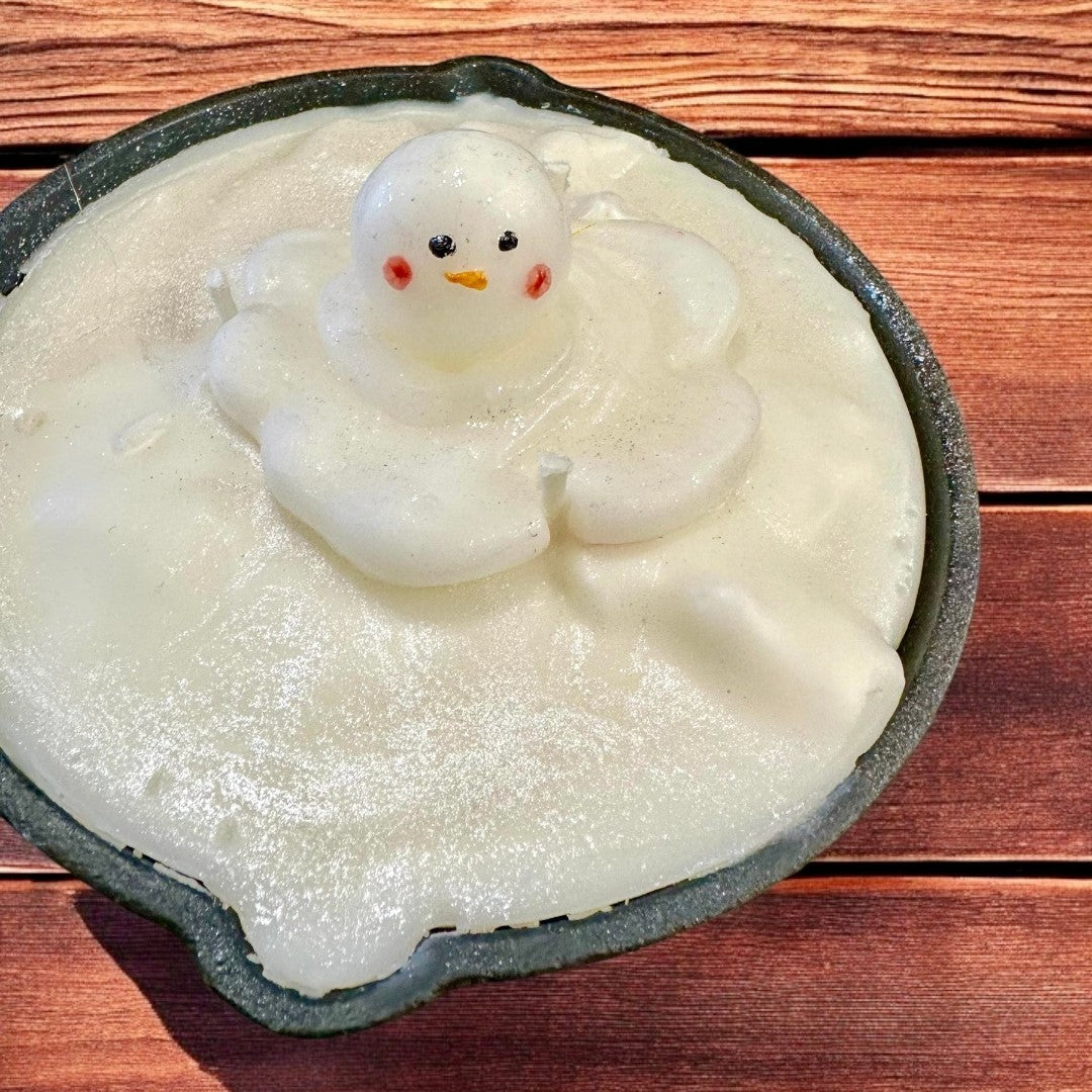 Melting Snowman Skillet candle featuring white wax and a melting snowman figure, perfect for holiday decor.