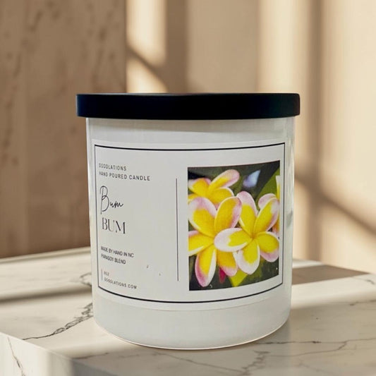 Bum Bum luxury candle in a white jar with a black lid, featuring a tropical floral label.