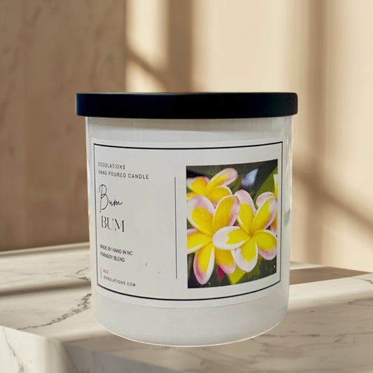 Bum Bum luxury candle in a white jar with a black lid, featuring a tropical floral label.