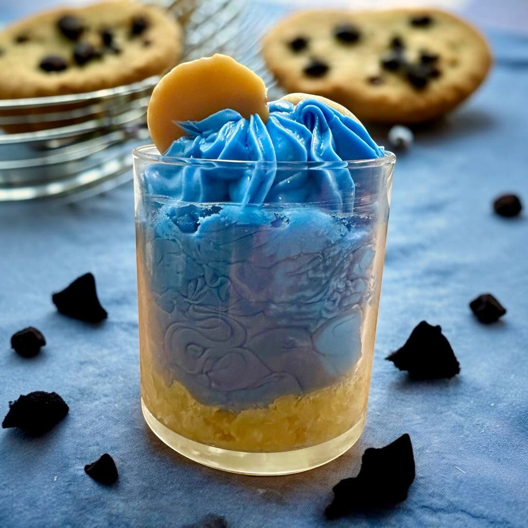Cookie Monster candle with blue frosting, candy eyes, and cookie accents. Chocolate chip cookie scented.
