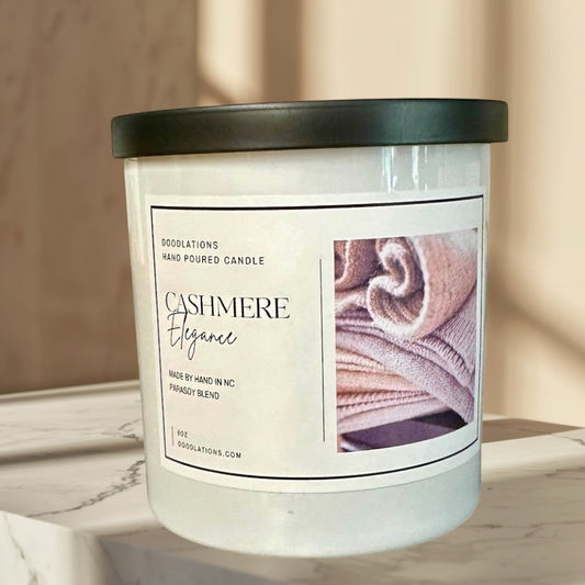 Doodlations Cashmere Elegance hand-poured candle in a white jar with a black lid, featuring a cozy cashmere texture image.