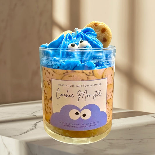 Doodlations Coffee Bar & Boutique Cookie Monster candle with blue frosting, candy eyes, and cookie accents. Chocolate chip cookie scented.