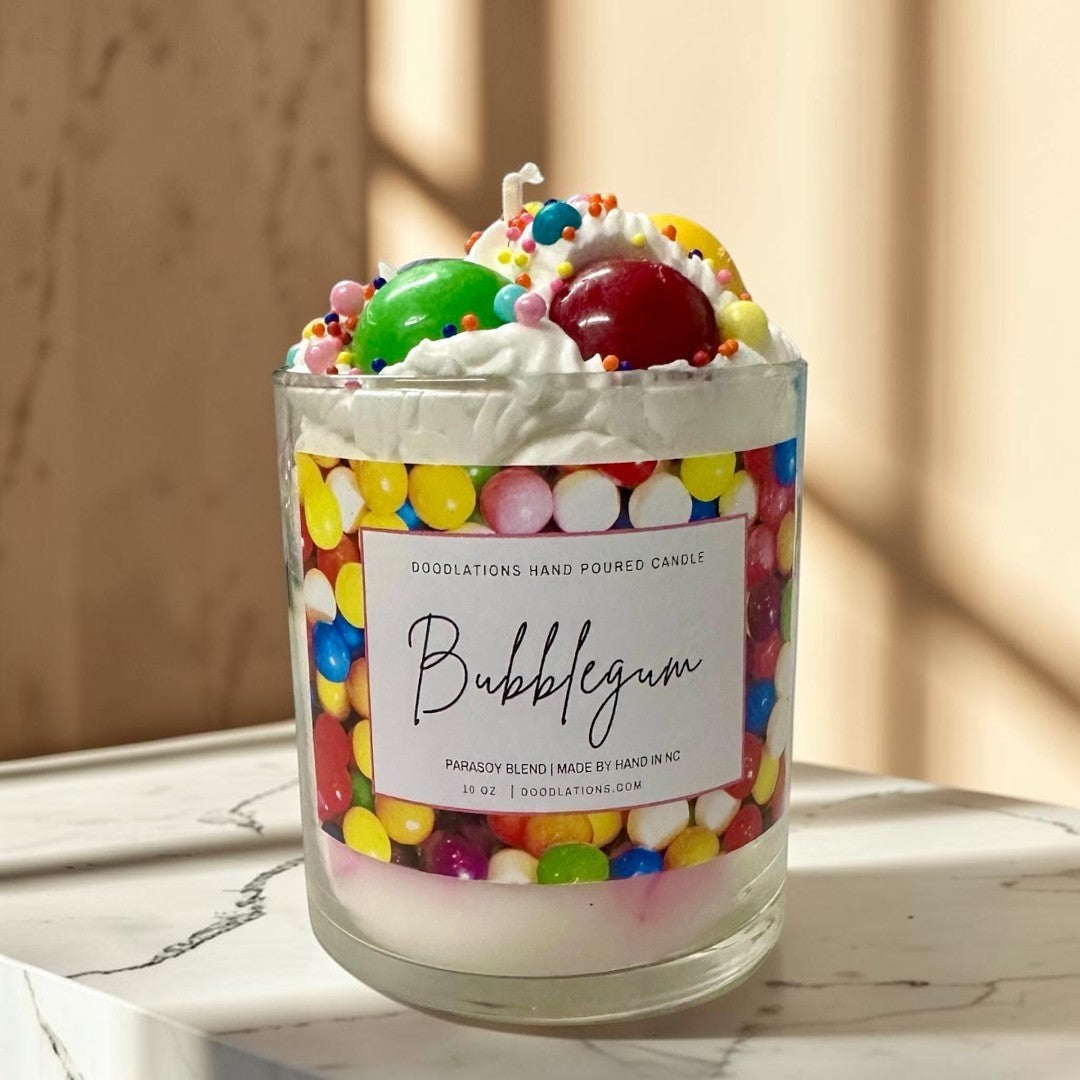 Doodlations Coffee Bar & Boutique Bubblegum candle with whipped wax topping, candy sprinkles, and a colorful gumball wrapper design.