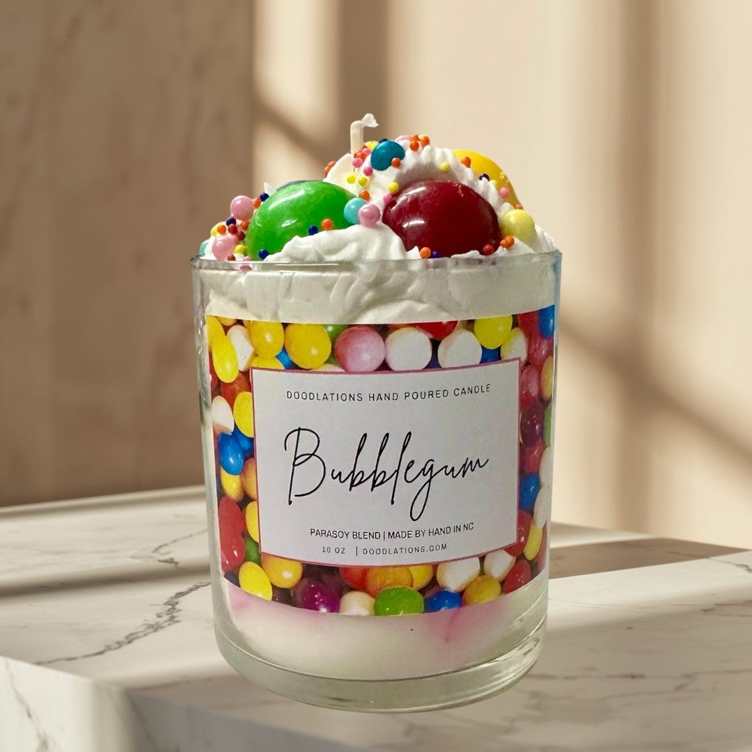 Doodlations Coffee Bar & Boutique Bubblegum candle with whipped wax topping, candy sprinkles, and a colorful gumball wrapper design.