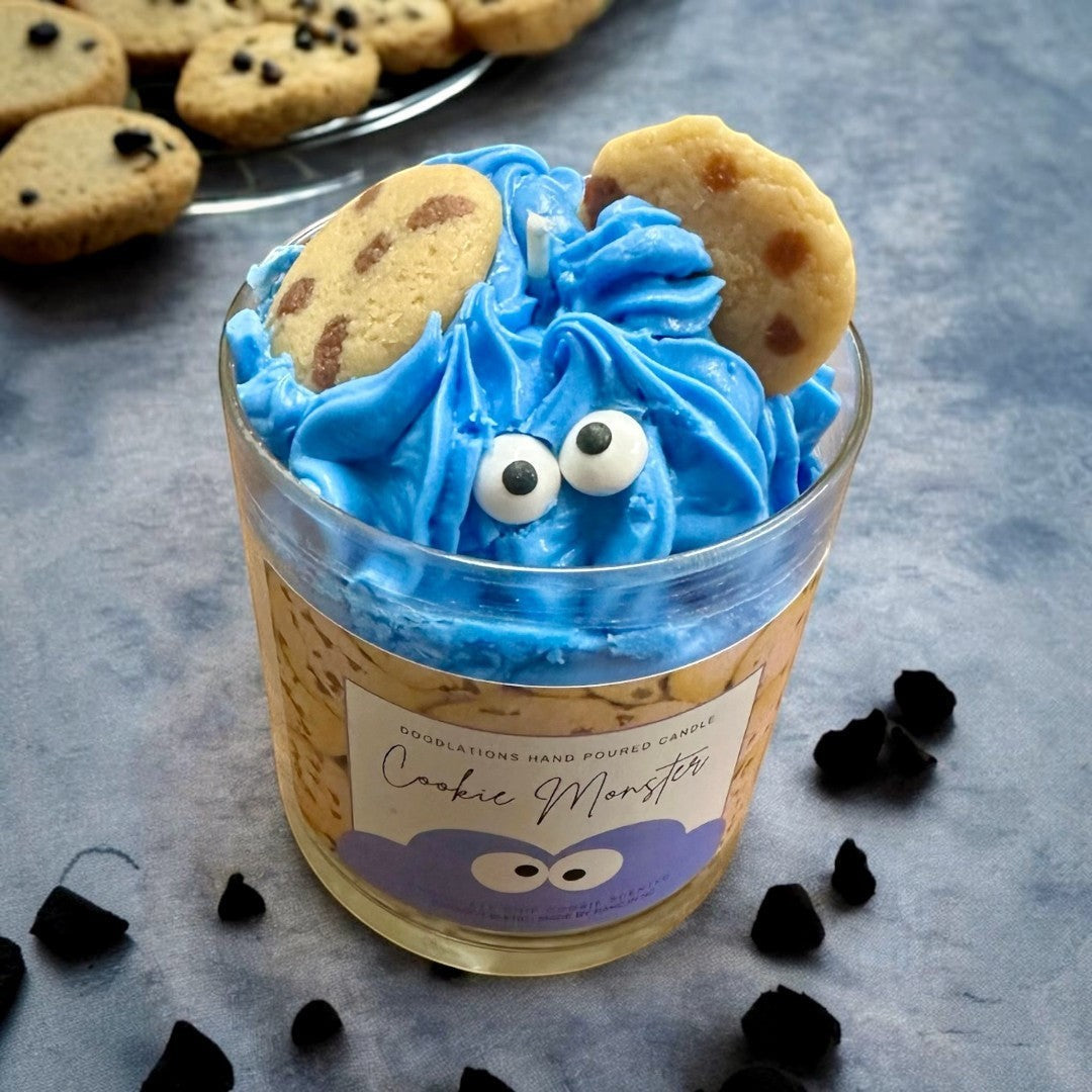 Cookie Monster candle with blue frosting, candy eyes, and cookie accents. Chocolate chip cookie scented.
