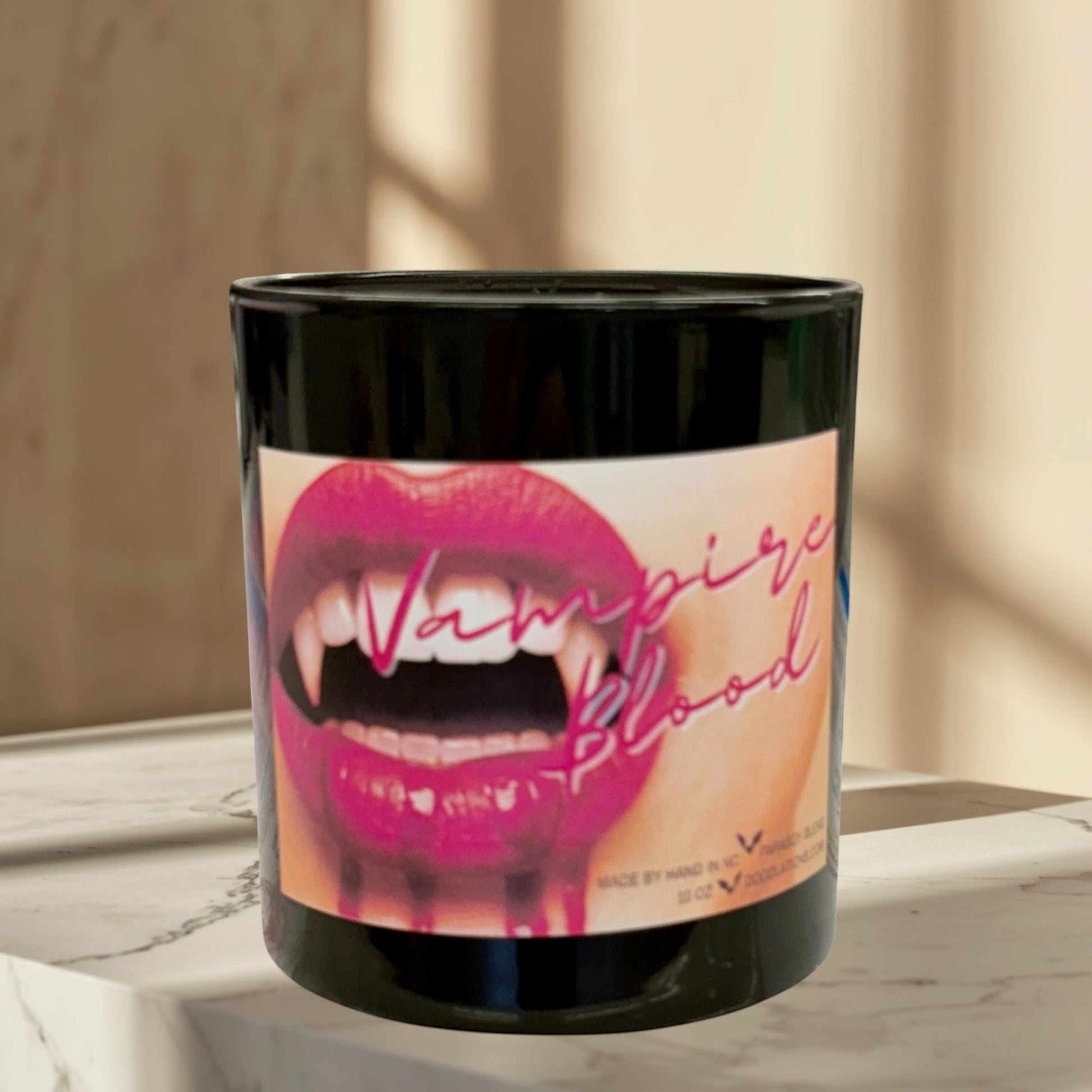 Doodlations Coffee Bar & Boutique Vampire Blood luxury candle with decorative wax fangs and bats. Bold berry, jasmine, amber scent.