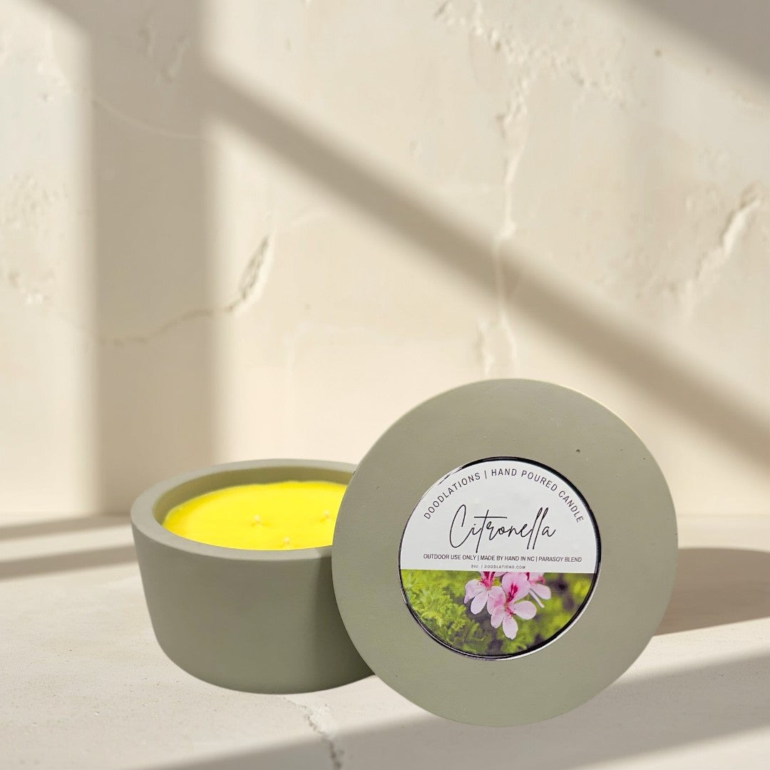 citronella candle in a grey concrete vessel with yellow soy blend wax. Outdoor decor.