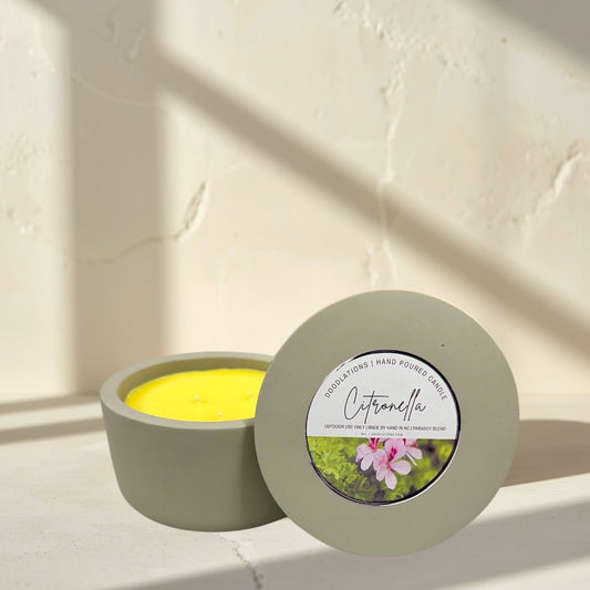 citronella candle in a grey concrete vessel with yellow soy blend wax. Outdoor decor.