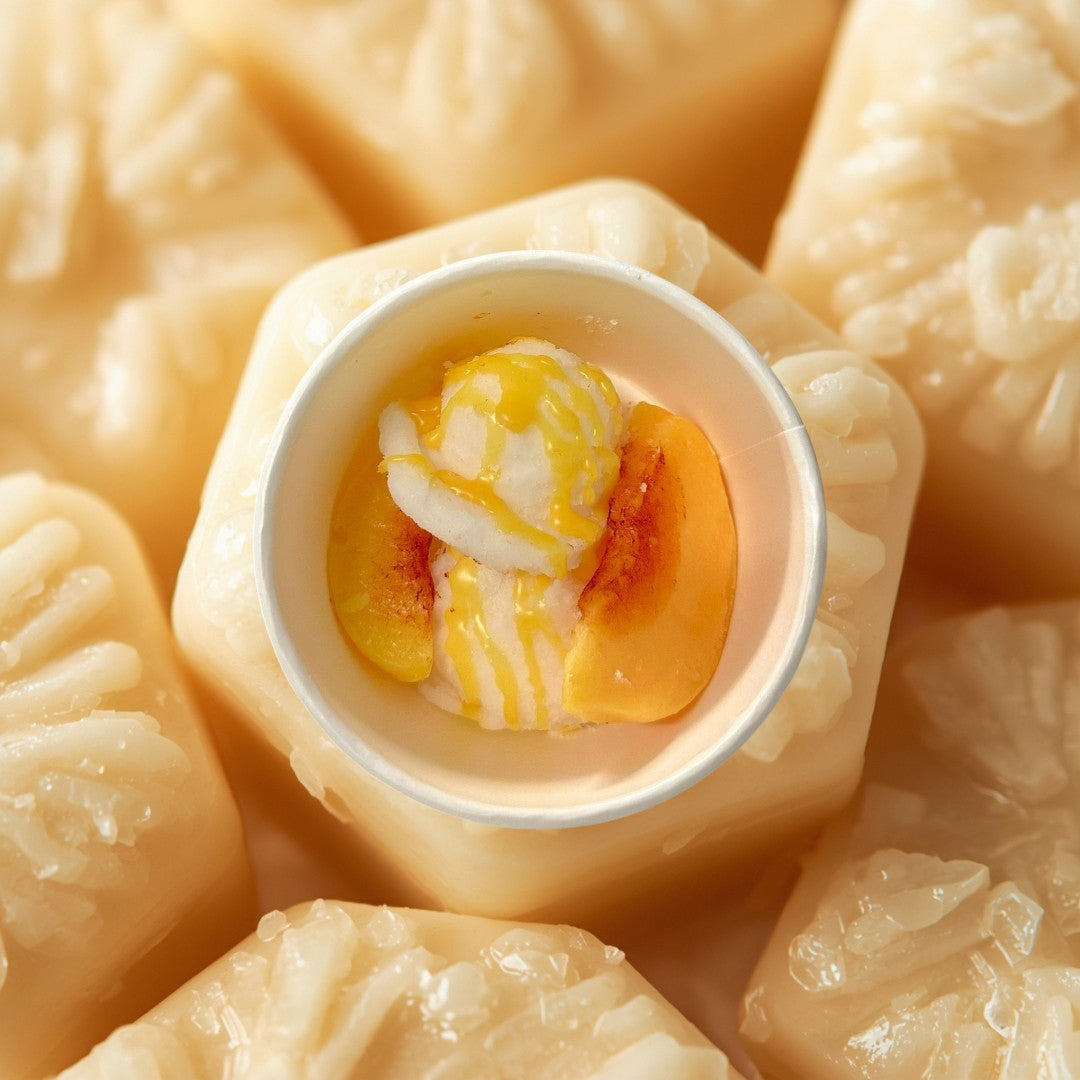 Peaches and Cream wax melts shaped like ice cream with peach slices and syrup.