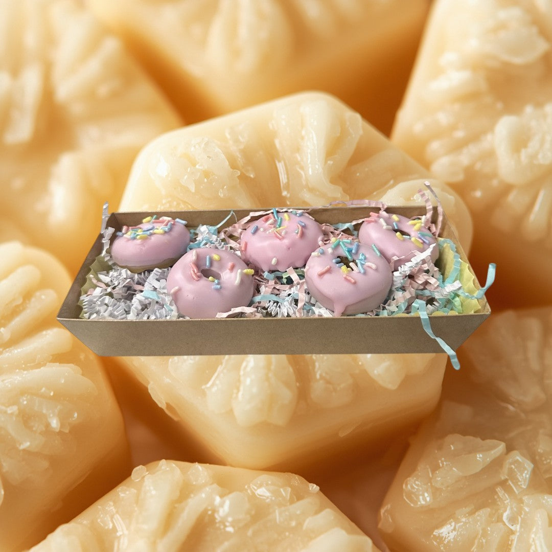 pink strawberry glazed donut wax melts with colorful sprinkles in a gift box.
