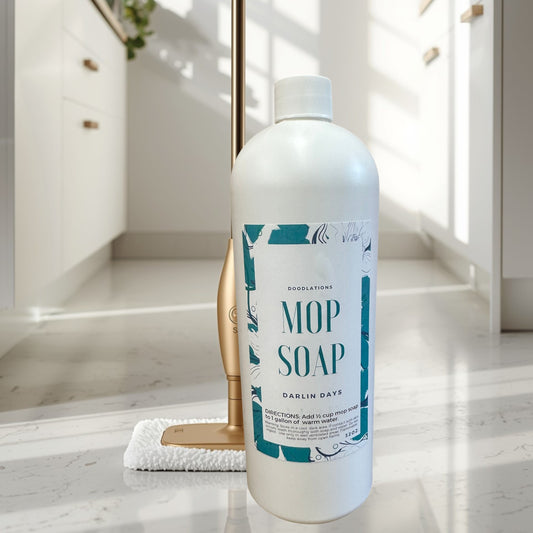 Darlin’ Days concentrated mop soap in a white bottle with a decorative label. A gold mop is behind it.