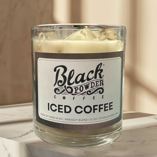 Black Powder Iced Coffee candle in a glass jar with a creamy white wax and faux ice cubes on top.