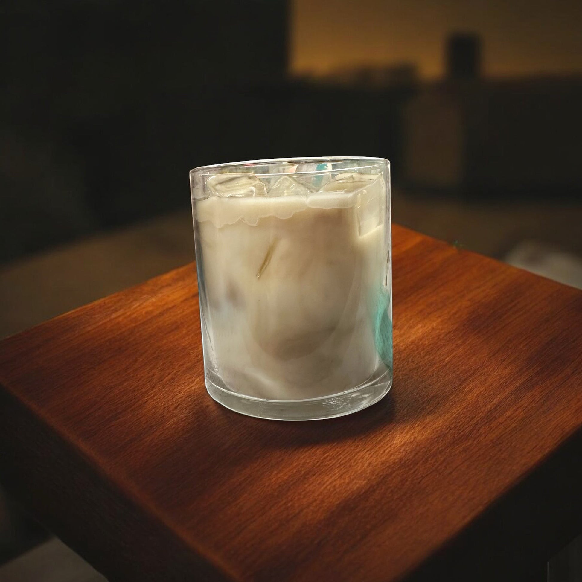 Black Powder Iced Coffee candle in a glass jar with a creamy white wax and faux ice cubes on top.