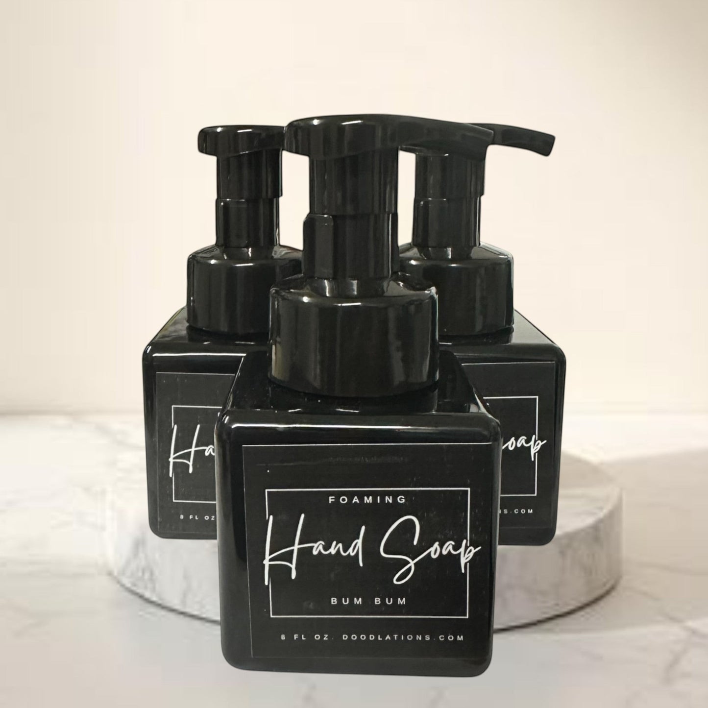 Doodlations Bum Bum foaming hand soap in a black bottle with a tropical floral background.